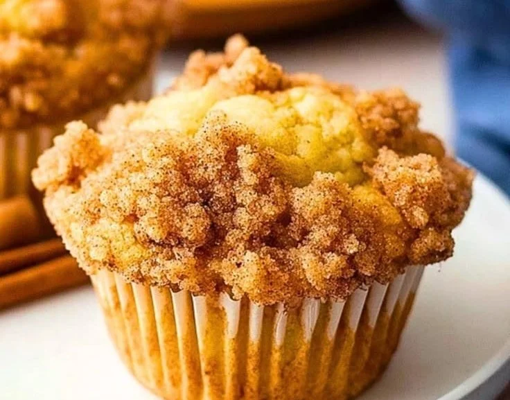 Homemade Apple Cinnamon Muffins fresh out of the oven, topped with crumbled cinnamon.