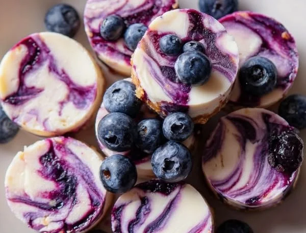 Blueberry swirl yogurt bites with fresh blueberries and creamy yogurt coating.