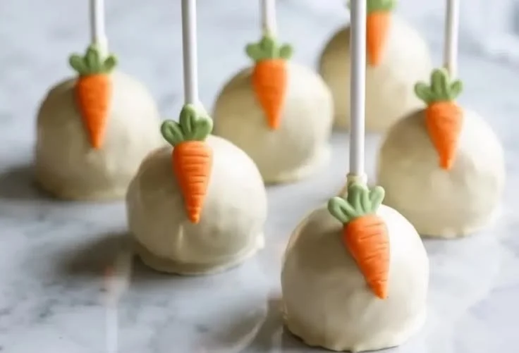 Delicious carrot cake pops decorated with cream cheese frosting and sprinkles.
