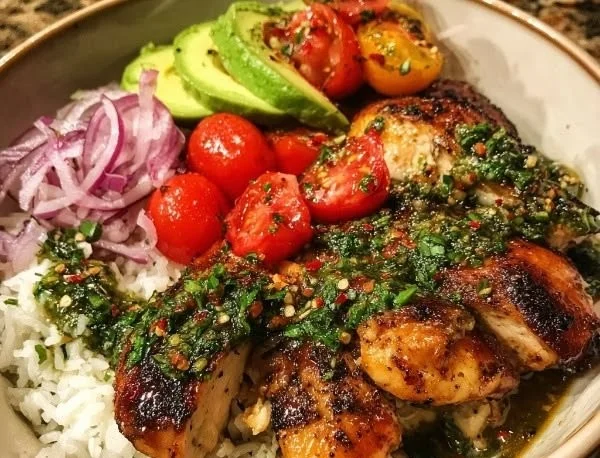 Chimichurri Chicken Bowls topped with garlic sauce on a rustic table