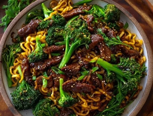 Plate of Chinese crispy beef served with broccoli noodles