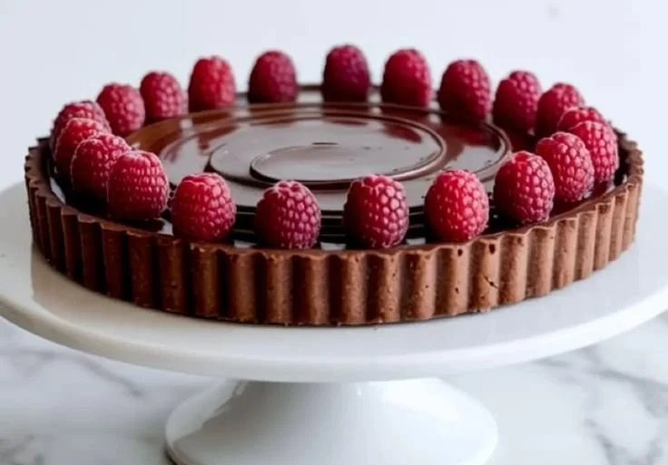 Delicious Chocolate Raspberry Tart topped with fresh raspberries and chocolate.