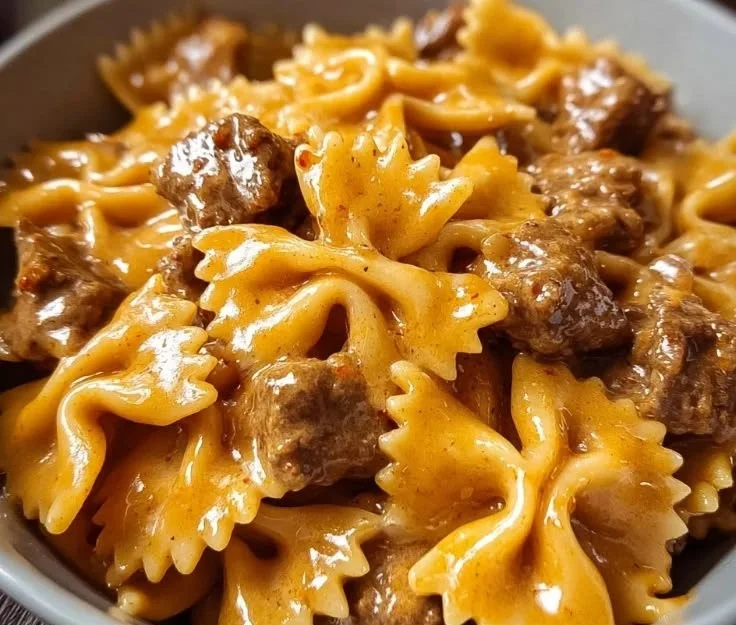 Creamy Velveeta beef with bow tie pasta served in a white bowl.