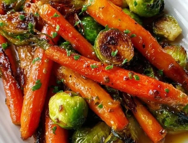Crispy maple glazed carrots and brussel sprouts served in a bowl
