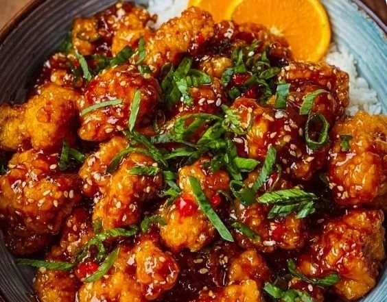 Delicious crispy orange chicken served with a zesty sauce on a plate