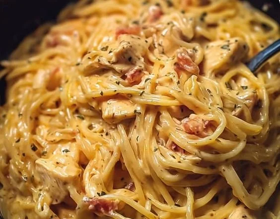 Crockpot Cheesy Chicken Spaghetti served in a bowl with melted cheese and herbs