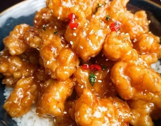 Delicious easy orange chicken recipe served on a plate with rice and vegetables