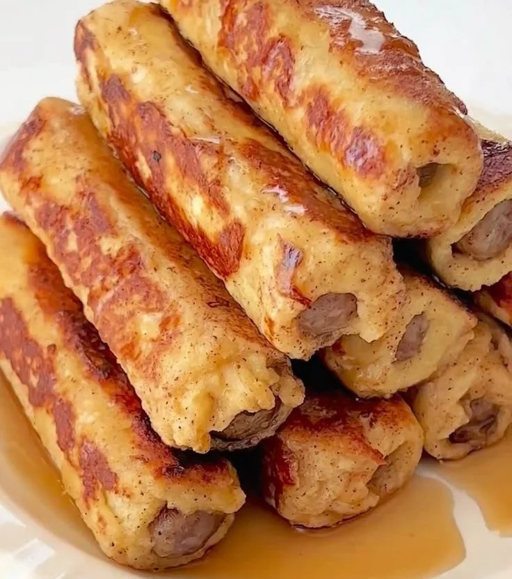 Delicious French Toast Roll-Ups served on a plate with syrup and berries