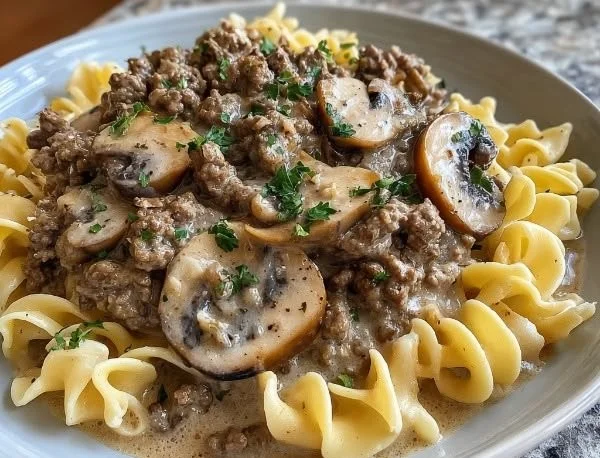 Delicious bowl of ground beef stroganoff served with noodles and garnished with parsley