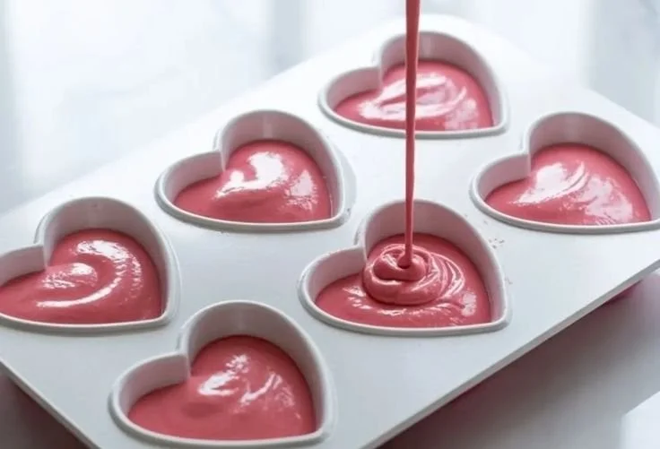 Heart-shaped raspberry mousse dessert topped with fresh raspberries.