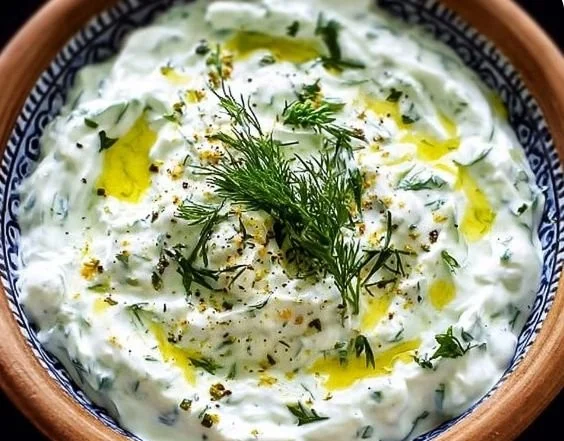 A bowl of homemade tzatziki sauce with fresh cucumber and garlic