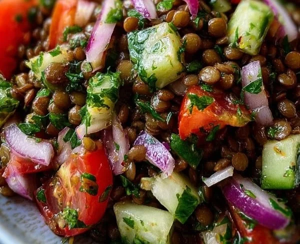 Colorful lentil salad with vegetables and herbs in a bowl