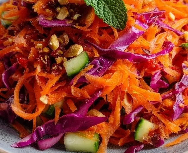 Fresh raw carrot salad with vibrant colors and healthy ingredients.