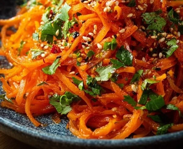 Bowl of savory spicy Korean carrot salad Morkovcha with fresh ingredients.