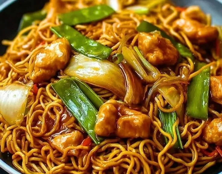Delicious stir-fried chicken noodles served in a bowl with vegetables