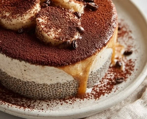 Delicious tiramisu chia pudding in a glass topped with cocoa powder and coffee beans
