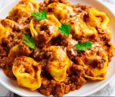 Cheesy Beef Tortellini Casserole served in a baking dish topped with cheese