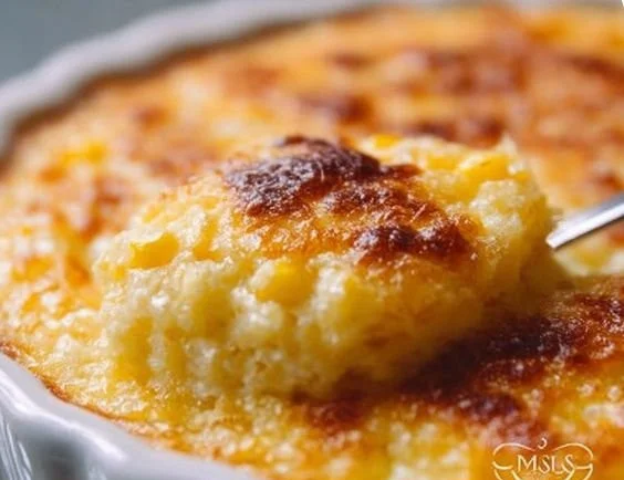 Bowl of classic corn pudding topped with fresh herbs and served warm.