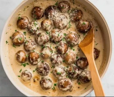 Creamy garlic parmesan sautéed mushrooms in a skillet