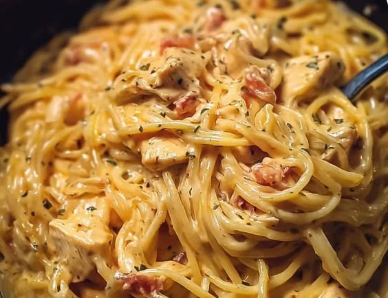 Crockpot Chicken Spaghetti with Cheese served in a bowl topped with herbs