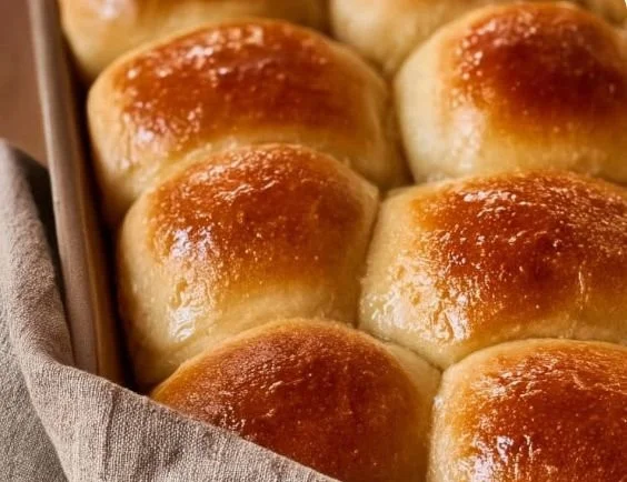 Freshly baked easy sourdough discard dinner rolls on a wooden table