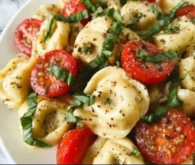 Delicious Garlic Parmesan Tortellini Salad served in a bowl with fresh ingredients.