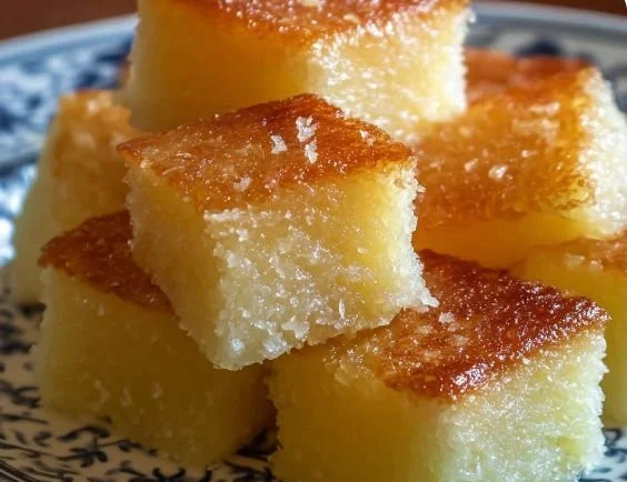 Delicious Hawaiian Butter Mochi served on a plate with fresh coconut topping.