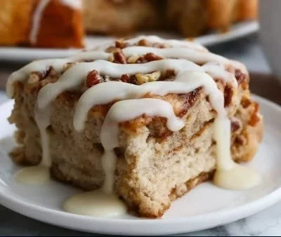 High-protein cinnamon roll baked oatmeal in a bowl, garnished with cinnamon and nuts.