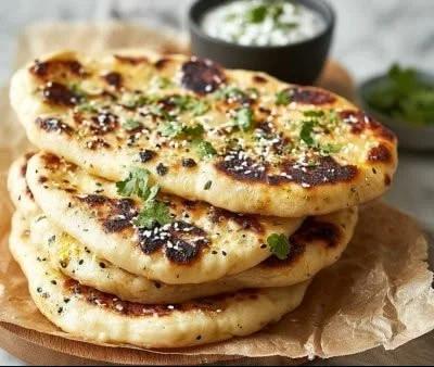 Freshly made Keto Naan Bread with herbs on a wooden cutting board