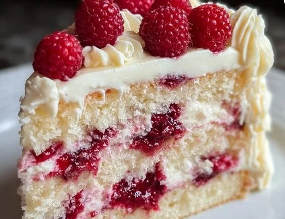 Decadent white chocolate raspberry dream cake with fresh raspberries on top