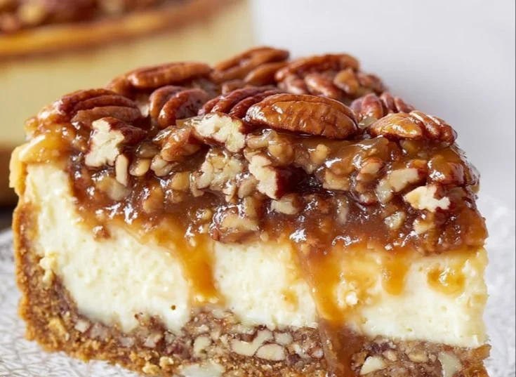 Decadent cheesecake topped with caramel sauce and crunchy pecans