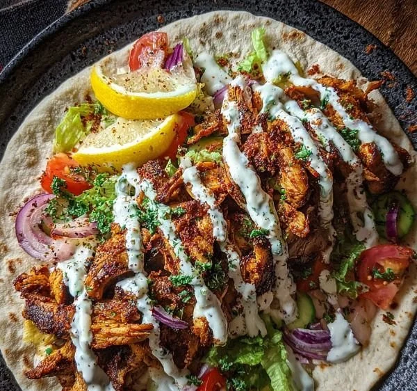 Garlic Sauce Chicken Shawarma served with pita and fresh veggies on a plate