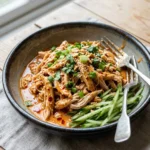 Delicious Bang Bang Chicken served with spicy sauce and garnished with green onions.